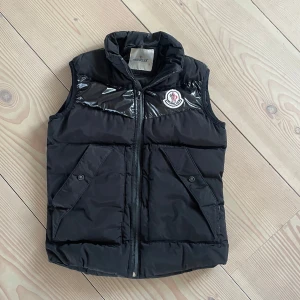Moncler Väst - Tja, säljer denna Moncler väst i storlek S, Men passar även M. Perfekt till sommaren och hösten. Den har få tecken på användning, skick: 8,5/10. Hör av er vid frågor eller funderingar!