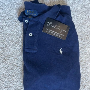 Mörkblå pikétröja från Polo Ralph Lauren - Klassisk mörkblå pikétröja från Polo Ralph Lauren! Jag säljer den för den inte passar mig nypris runt 1000 och säljer för 349. Storlek 14-16 år! 