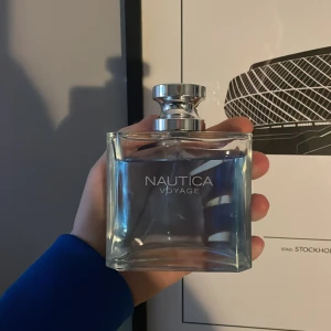 Nautica Voyage Eau de Toilette 100ml - Fräsch och maskulin parfym från Nautica, Voyage. Kommer i en stilren, transparent glasflaska med silverfärgad kork. Innehåller 100 ml Eau de Toilette, perfekt för dig som gillar marina och friska dofter. Har tyvärr inte boxen då jag tappade bort den. 