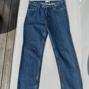 Blå raka jeans från Gina tricot - Klassiska blå jeans med rak passform och fem fickor. Jeansen har  lågmidja och stängs med dragkedja och knapp. Storlek 38 ifrån Gina tricot och använts två gånger 