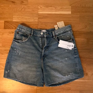 Blå jeansshorts från ZARA - Klassiska blå jeansshorts från ZARA i 100% bomull. Modellen har fem fickor, knapp och dragkedja framtill samt råa benslut. 