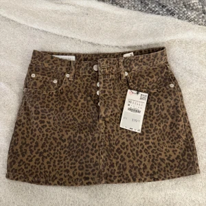 Leopardmönstrad minikjol från Zara - Säljer en snygg leopardmönstrad minikjol från Zara Kjolen har klassisk femficksdesign, knappar framtill och är i en brun och svart färgskala. Perfekt statement-plagg för dig som vill sticka ut.