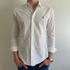 Vit skjorta från Ralph Lauren - Helt ny skjorta från polo Ralph lauren ändast använd 1 gång!! Skjortan har en marin blå logga på bröstet och har inga fläckar eller liknande✅ Nypris:1200 Mitt pris: 449kr🤩 Det är bara att skriva om du har några funderingar😁🔝