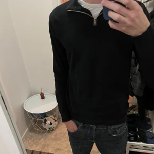 Svart quarter zip - Säljer en svart långärmad tröja från Jack & Jones med halv dragkedja vid kragen.