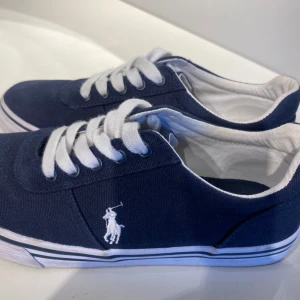 Mörkblå sneakers från Polo Ralph Lauren - Snygga mörkblå sneakers från Polo Ralph Lauren. Endast använda 1 gång eftersom de är för små. Är öppen för prisförslag💕💕skriv vid frågor!!☺️☺️