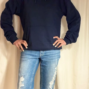 Mörkblå hoodie från Gina Tricot  - Säljer en enkel och stilren mörkblå hoodie från Gina. Tröjan har huva, lång ärm och en klassisk känguruficka framtill. Jätte bra skick, helt oanvänd och prislappen kvar. 