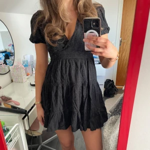 Svart klänning från Zara - Snygg svart klänning från Zara med korta puffärmar och v-ringning. Klänningen har en volangdetalj och är perfekt nu inför sommaren!! Endast använd en gång och kommer inte till användning längre 💕 Skriv för mer bilder eller info!! (Pris kan alltid diskuteras)🫶 OBS!! Jag är 175 cm därav är den kort på mig 😇