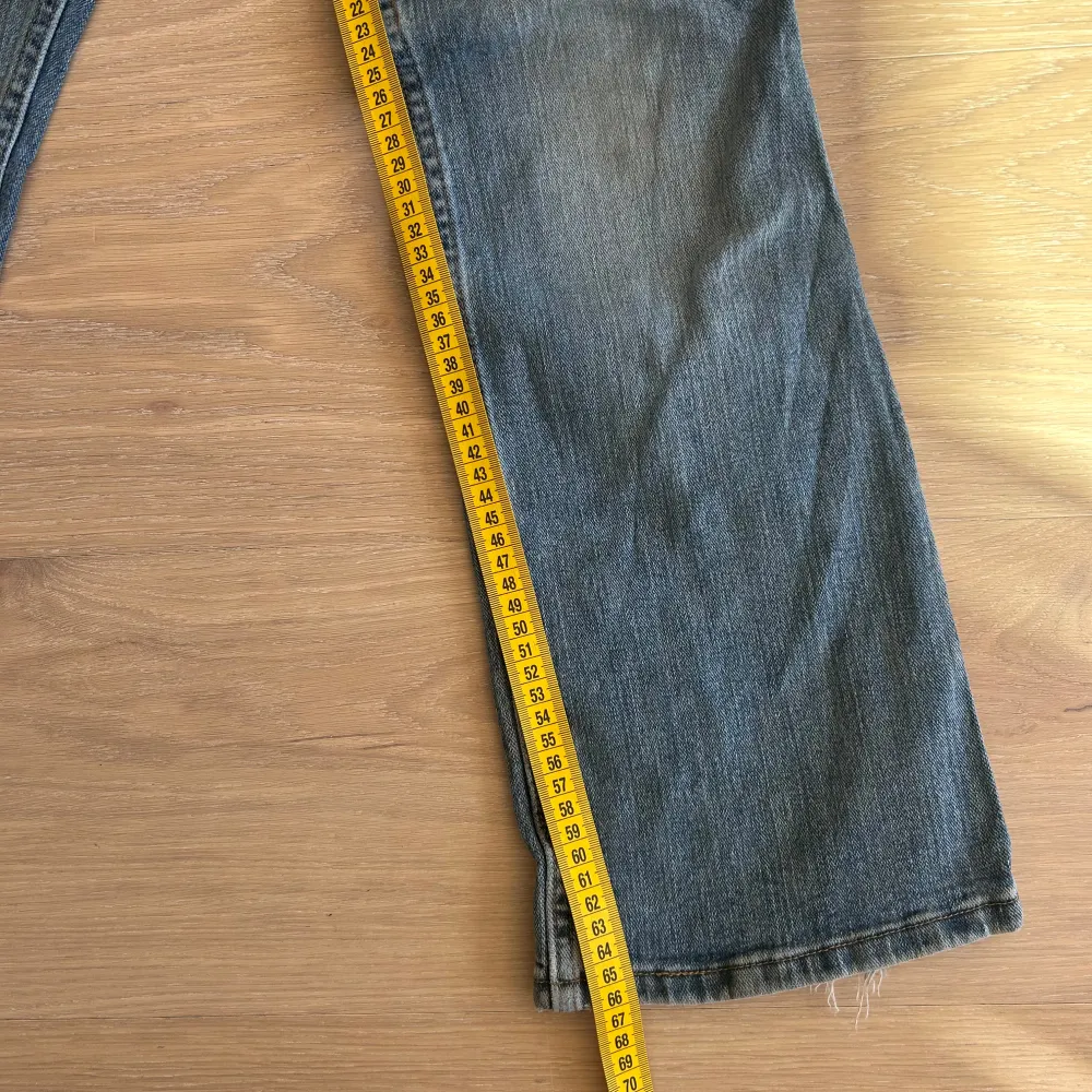 Säljer ett par klassiska blå jeans med dragkedja och knappstängning. De har en rak passform och fem fickor. Perfekta för en avslappnad stil. Mått i bild . Farkut & Housut.