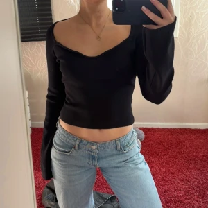 Svart långärmad croppad topp - Snygg svart långärmad topp med croppad passform. Perfekt för både en middag, utgång eller vardag. 
