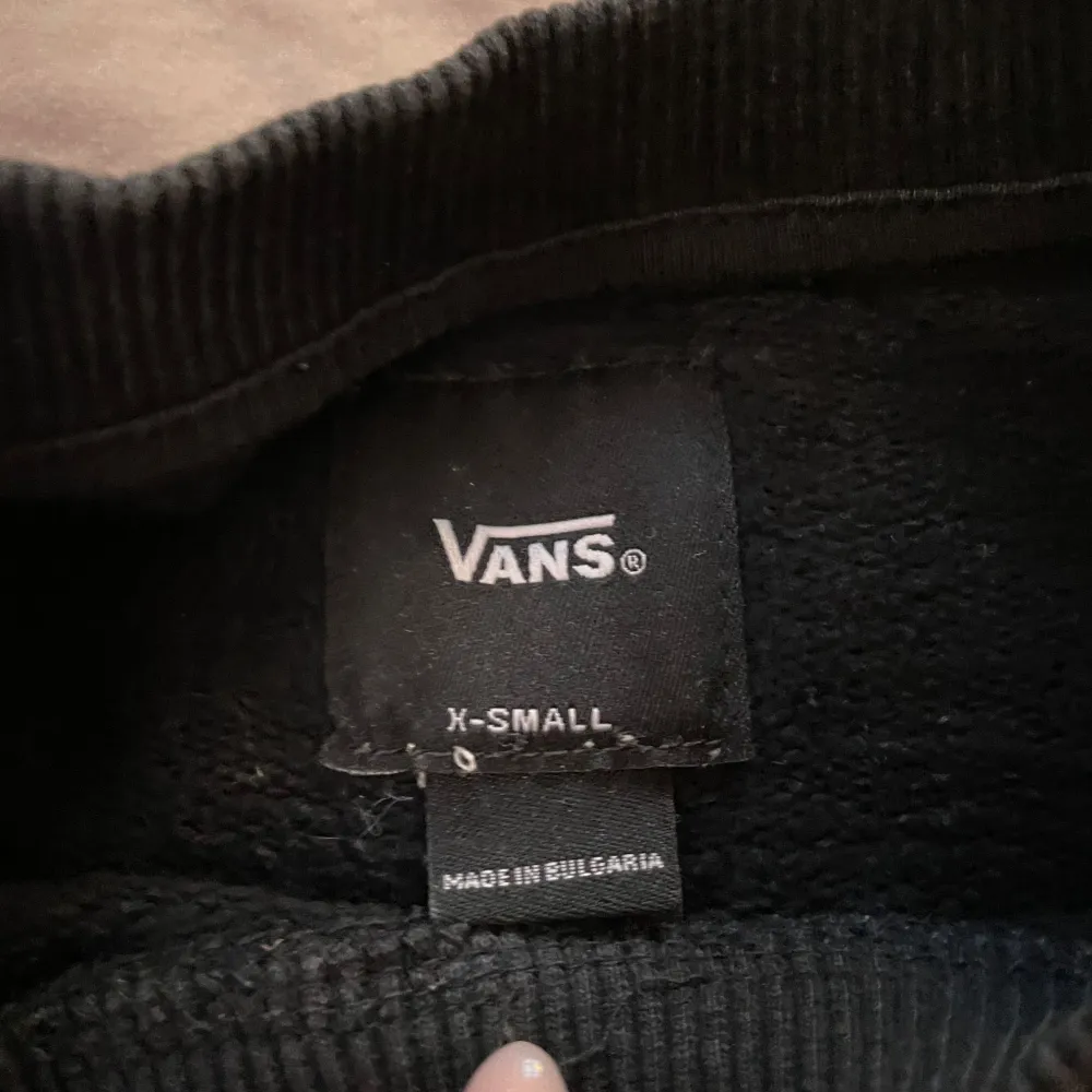 Säljer en svart långärmad tröja från Vans med deras ikoniska logga i vitt på bröstet.. Neuletakit & Villapaidat.