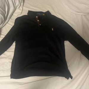 pikétröja från Ralph Lauren - Säljer en stilren svart pikétröja från Ralph Lauren i slim fit då den är för stor på mig, använt ett par gånger men har inga defekter. Storleken är m men den passar s