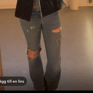 Blå jeans med slitningar - Snygga blå jeans med slitningar på knäna och en bootcut-stil. Perfekta för en avslappnad look med en touch av edge.
