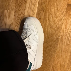 Vita sneakers från New Balance - Säljer ett par vita sneakers från New Balance med snörning och rund tå. Skorna har en stilren design med en tjock sula och diskreta detaljer i svart på hälen. Perfekta för en avslappnad stil. Modellen heter CT302🥰🥰🥰