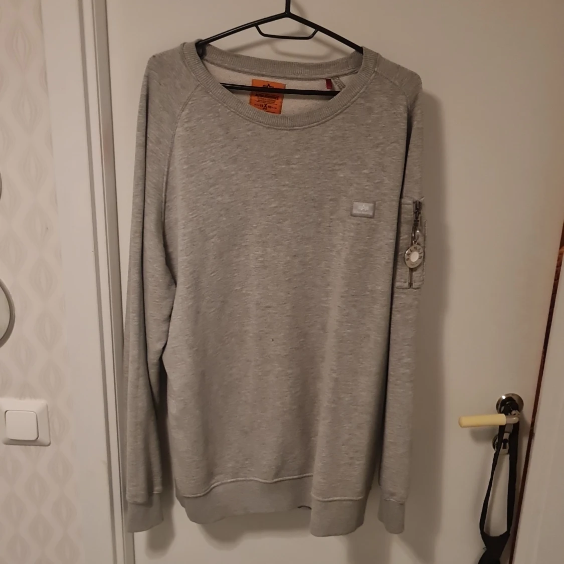 Grå sweatshirt från Alpha Industries har balmain på armen