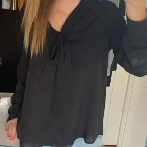 Gina tricket svart blus med knyte - Svart blus med knyte från Gina trixig som inte har några missfärgningar eller hål. Precis som i nyskick och har sällan använts.