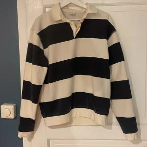 Randig tröja med krage från Zara -  Svartvit randig tröja från Zara. Tröjan har långa ärmar och krage. Tveka inte på att skriva