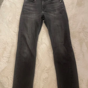 Svarta jeans från Calvin Klein - Snygga svarta jeans från Calvin Klein med klassisk femficksdesign och subtila slitningar. Jeansen har en rak passform och är inte för tajta. Nypriset var 1100kr