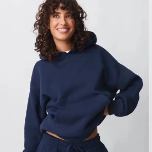 Mörkblå hoodie - Säljer en stilren mörkblå hoodie med klassisk design. Den har en stor ficka framtill och en bekväm huva. Perfekt för en avslappnad look. 