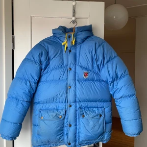 Fjällräven expedition jacka - Vintage Fjällräven expedition jacka i strl XXXS. Jättefint skick och allt fungerar, både knappar och dragkedja. Inlämnad på kemtvätt förra vintern och sparsamt använd efter det. Lite missfärgningar på framfickorna pga att den har några år på nacken men ser bättre ut i verkligheten än på bilderna. Ljuset får det att se värre ut! Lite smutsig på insidan av ärmarna också men borde försvinna efter en kemtvätt till. 
