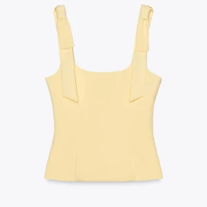 Gul topp med knytband Zara - Snygg gul topp med breda axelband med rosetter. Helt slutsåld på hemsidan. Helt ny med lappen kvar.