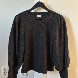 Svart stickad tröja från Jacqueline de Yong - Säljer en snygg svart stickad tröja från Jacqueline de Yong. Tröjan har långa ärmar med puffiga detaljer och en rund halsringning. Perfekt för kyligare dagar och ger en stilren look.🤍
