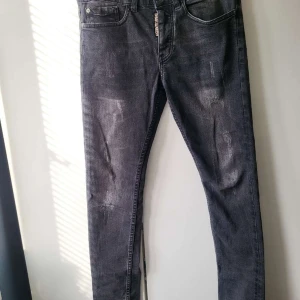 Dsquared2  jeans  - Snygga svarta jeans från Dsquared2 med en cool tvättad look. De har en klassisk femficksdesign och en knappgylf med Dsquared2-logga. Perfekta för en stilren och modern look. Äkta 
