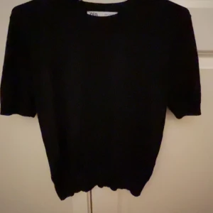 Svart kortärmad tröja  - Snygg svart tröja från Zara som har resår i midjan. Tröjan är knappt använd och är i väldigt mjukt och skönt material. Den är i storlek M men är mer som en S 