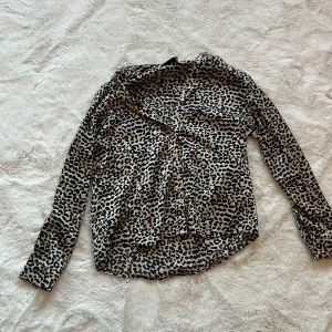 Leopardmönstrad blus från Neo Noir - Snygg leopardmönstrad blus från Neo Noir med knappar framtill. Perfekt för att ge din outfit en trendig touch. Blusen har långa ärmar och en bekväm passform.