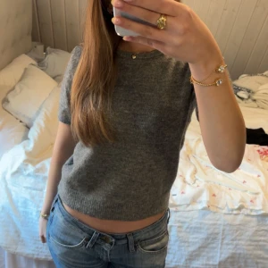 Grå stickad tröja - Säljer en stilren grå stickad tröja med korta ärmar. Kontakta mig för mer info! 