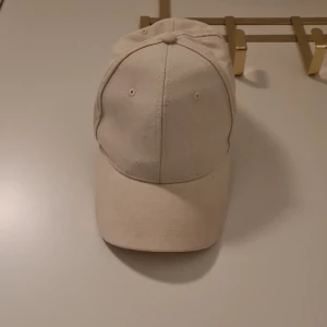 Beige keps från Dressmann - Snygg beige keps från Dressmann i linneblandning. Perfekt för en avslappnad stil. Justerbar rem baktill för optimal passform.