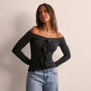 Söt topp  - Jättesöt off shoulder tröja från Nelly med volanger framtill, perfekt till utgång men passar också till vardags! Tröjan har silikon runt axlarna vilket gör att den verkligen sitter på plats. Endast använd en gång💗