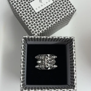 Peak Ring Edblad - Snygg och modern ring från Edblad i silverfärg med coola nitar. Kommer i originalförpackning. Storlek: S (16,8mm) Rostfritt stål, nickel säker och vattentålig. Den är använd men är i bra skick fortfarande. Finns lite små repor och är lite ”smutsig” mellan nitarna om man kollar noga men det är inget som syns. Säljer då den inte längre kommer till användning💕