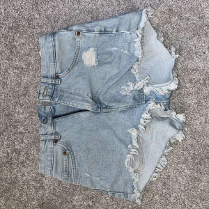 Ljusa jeansshorts från H&M - Säljer ett par ljusa jeansshorts från H&M. De har en knapp och dragkedja framtill samt fickor både fram och bak. jättefina och perfekt till sommaren!! inga skador eller fläckar på dom! dom är som ny!