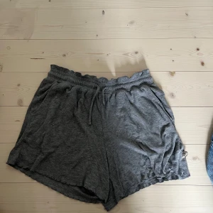 Grå ribbade shorts från Pomp de Lux - Mysiga grå shorts från Pomp de Lux med ribbad struktur och resår i midjan samt snörning. Perfekta för en avslappnad stil eller hemmabruk.