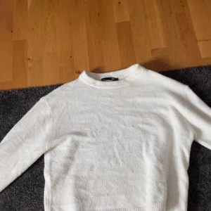 Vit stickad tröja - Mysig vit stickad tröja med rund halsringning och långa ärmar. Perfekt för lager-på-lager och enkel att matcha med olika outfits.