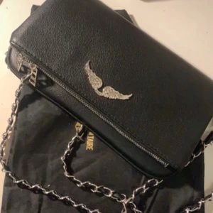 Zadig Voltaire väska  - Säljer en svart axelväska från Zadig Voltaire  med 2 band, en längre och en kortare. Väskan har mycket utrymme. Stora storleken 