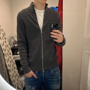 Fullzip från East West i nyskick - Tja! Säljer denna riktigt schyssta fullzippen från East West! Använd max 10 gånger och i nyskick! Nypris är 900kr, men jag säljer den för 399kr! Pris alltid diskuterbart vid snabb affär! För fler frågor, tveka inte att kontakta mig! //FashionLabbet