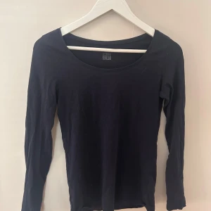 Marinblå långärmad tröja - Säljer en stilren marinblå långärmad tröja från KappAhl, tillverkad i ekologisk bomull. Perfekt för en minimalistisk garderob. 