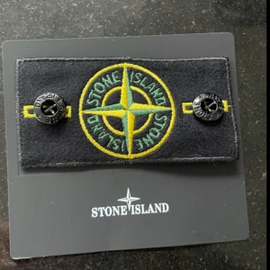 Svart tröja från Stone Island - Säljer en stilren svart tröja från Stone Island med deras ikoniska märke på ärmen. Tröjan har långa ärmar och en rund halsringning. Perfekt för en avslappnad och trendig look.