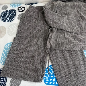 Grå ribbade byxor från Zara - Säljer ett par grå ribbade byxor från Zara med knytband i midjan. Byxorna har en loose passform och är tillverkade i ett mjukt, stickat material som är perfekt för en avslappnad stil.Träjan passar dig för storlek S och M 