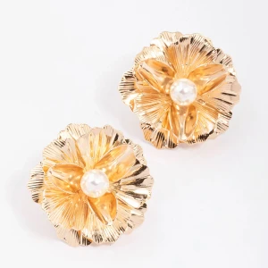 Guldiga blomformade örhängen med pärldetalj - Säljer ett par eleganta örhängen i guldton, formade som blommor med en vit pärla i mitten. Perfekta för att ge din outfit en lyxig touch. Blommornas detaljer ger ett unikt och stilrent intryck.