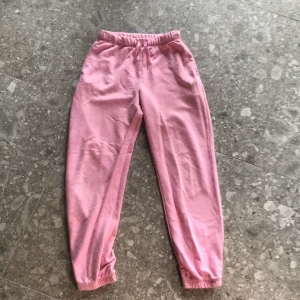 Rosa mjukisbyxor från H&M - Säljer ett par ljusrosa mjukisbyxor från H&M i storlek 146. Byxorna har resår i midjan och vid bensluten för en bekväm passform. Perfekta för en avslappnad stil.