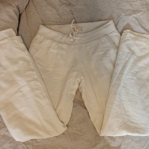 Vita linne byxor med snörning - Säljer ett par bekväma vita linne byxor med snörning i midjan. Byxorna har en avslappnad passform och är perfekta för en chill dag hemma. De har praktiska fickor framtill och en elastisk midja för extra komfort. Väldigt lowrise på. Mycket bra skick utan snörningen vilket är lite rufsigt.