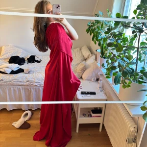 Röd axelbandslös långklänning - Elegant röd långklänning med en axelbandslös design. Perfekt för bal eller liknande. Den är specialbeställd från en skräddare så du är garanterat unik med denna. Storleken är ungefär en M kan nog passa L också. Jag är 176 lång och den är ner till golvet på mig. Skriv vid frågor eller mått☺️köpt för 3500 aldrig använd