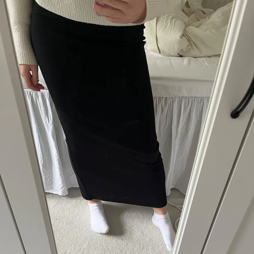 Säljer en fin lång svart kjol med ribbade kanter och slits💕Jätteskönt material med mycket stretch, kjolen sitter löst ner till så den drar ingenting när man går, man kan gå fritt utan att den sträcker sig efter benen, Jättefin och passar till allt☺️. Hameet.