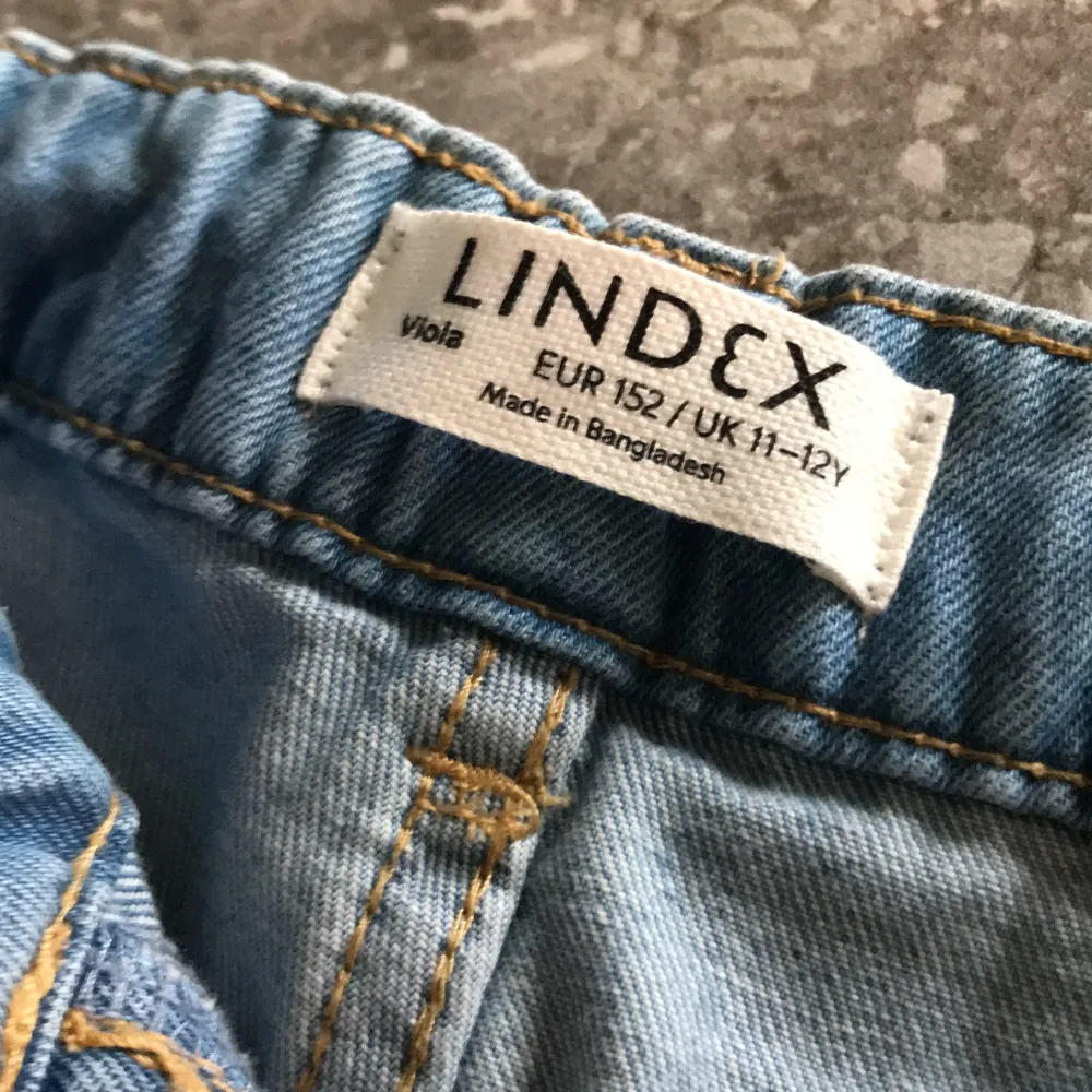 Säljer ett par ljusblå jeans från Lindex, modell Viola. Byxorna har wide leg passform och är croppade i benen. Klassisk femficksdesign och hög midja. Perfekta för en avslappnad och trendig stil.. Farkut & Housut.