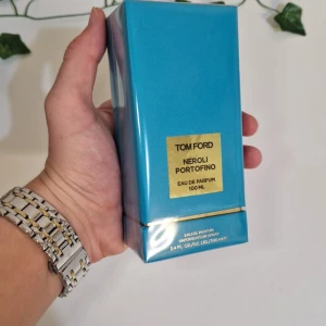 Tom Ford Neroli Portofino Eau de Parfum 100 ml - Säljer en lyxig Tom Ford Neroli Portofino Eau de Parfum i en elegant turkos förpackning. Flaskan innehåller 100 ml av denna fräscha och citrusdoftande parfym, perfekt för den som älskar exklusiva dofter. Förpackningen har en stilren design med gulddetaljer.