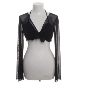 Svart mesh bolerotopp - Snygg svart bolerotopp i mesh med långa ärmar och knytning fram. Perfekt för en trendig lager-på-lager-look. Toppen är croppad och har en stilren design som passar till många olika outfits.