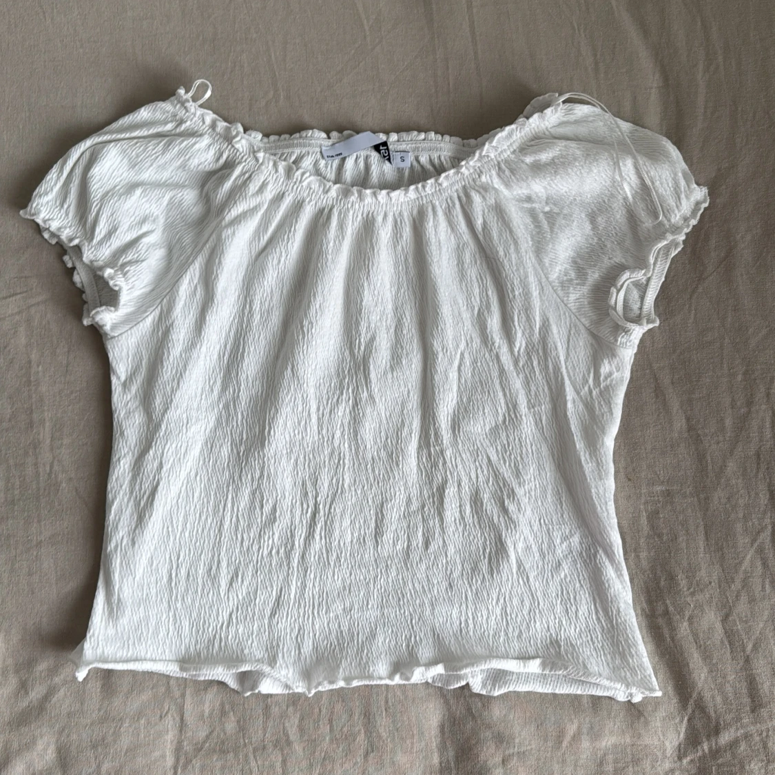 Vit ribbad topp med volangkant