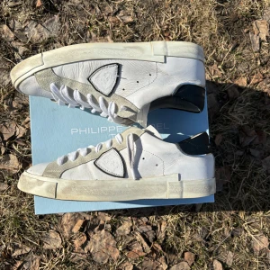 Philippe Model - Säljer ett par vita sneakers från Philippe Model med grå mockadetaljer och svart häl i storlek 41. Skorna är i väldigt bra skick. Nypris 3899:- Mitt pris 1399:- men priset går att diskutera vid snabb affär! Endast skorna ingår. 😃👍🏻